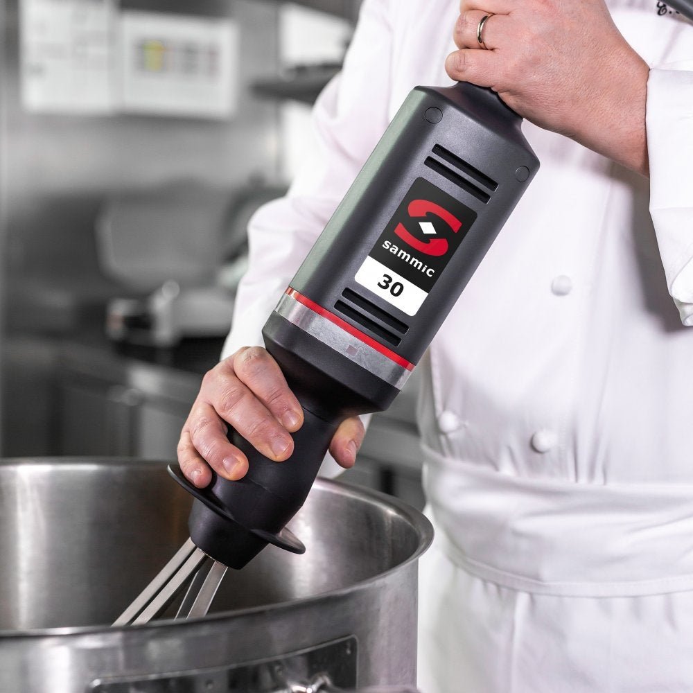 Chef utilizando el batidor de mano profesional Sammic B-30 con accesorio de varillas batidoras, ideal para montar nata, batir claras y preparar mezclas en cocinas industriales.