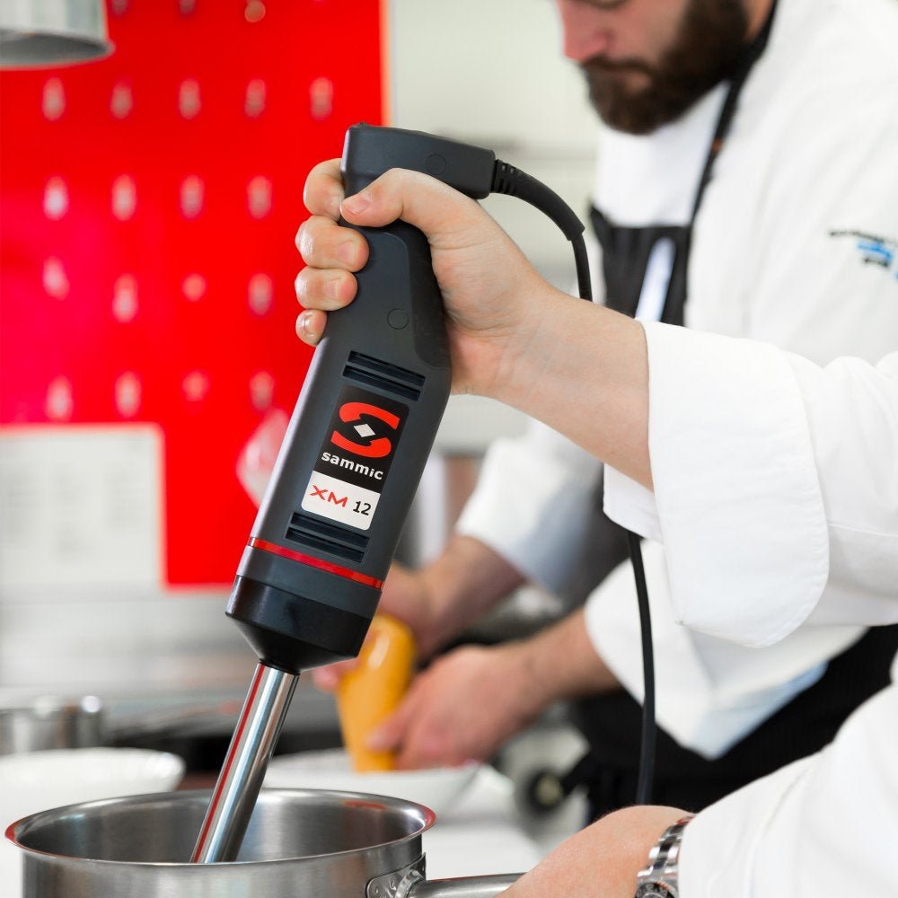 Chef utilizando el batidor de mano profesional Sammic XM-12 en una cocina, ideal para preparar salsas, cremas y emulsiones con precisión y potencia.