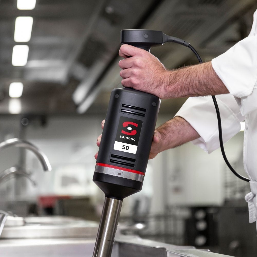 Chef utilizando el batidor de mano profesional Sammic XM-51 en una cocina industrial, ideal para procesar grandes volúmenes de alimentos con precisión y potencia.